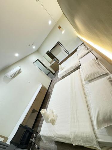 a large white bed in a room with windows at STAR HOTEL in Tawau