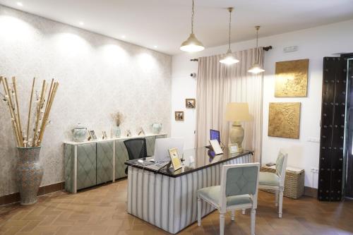 a lobby with a counter with chairs and a table at Hospedarte Cazadero Real in El Rocío