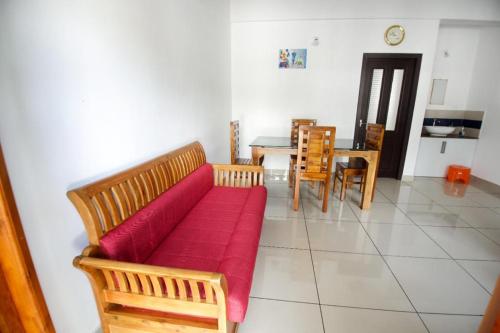 a living room with a red couch and a table at Wayanad Rooms Izza in Sultan Bathery