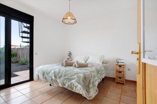a bedroom with a bed and a glass door at Casa Vicente Majanicho in Lajares