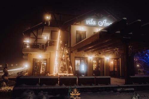 a building with a sign on the side of it at night at Vila Ana in Kalesija