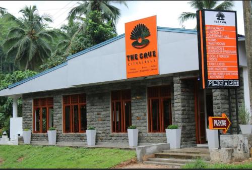 un edificio con un letrero naranja delante de él en Cave Kithulgala en Kitulgala