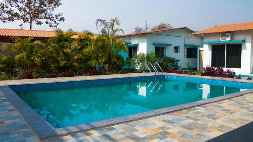 a swimming pool in front of a house at Mohor Retreat in Alibag
