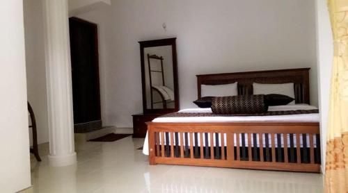 a bedroom with a wooden bed and a mirror at Cave Kithulgala in Kitulgala