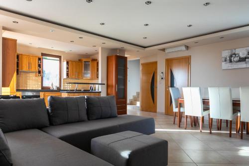 a living room and kitchen with a couch and a table at Villa della Vita in Pécs