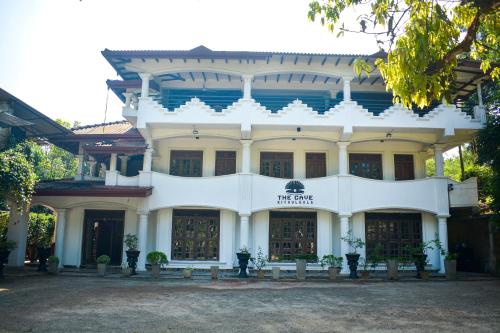 um edifício branco com um sinal em frente em Cave Kithulgala em Kitulgala