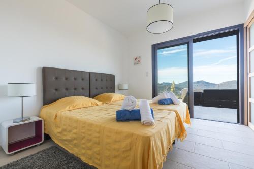 een slaapkamer met twee bedden en een groot raam bij Villa Bumortu in Olmeto