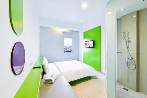 Habitación hospitalaria con cama y ducha en POP! Hotel Kelapa Gading, en Yakarta