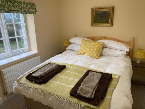 um quarto com uma cama com toalhas em Canalside boathouse in the park em Abergavenny