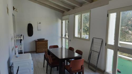 ein Esszimmer mit einem Tisch und Stühlen in der Unterkunft La Rosa dei Venti in Teulada