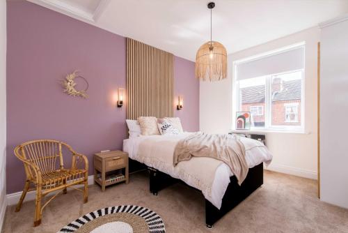 a bedroom with a bed and a chair and a window at Railway Apartments Rugby in Rugby