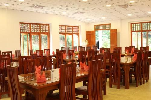 uma grande sala de jantar com mesas e cadeiras de madeira em Cave Kithulgala em Kitulgala