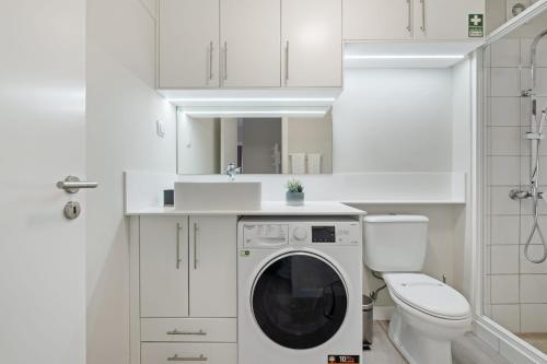 a white bathroom with a washing machine and a toilet at Imperatriz I - By wehost in Funchal