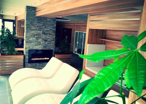 a living room with two white chairs and a fireplace at Apartman Panorama 1001 in Štrbské Pleso