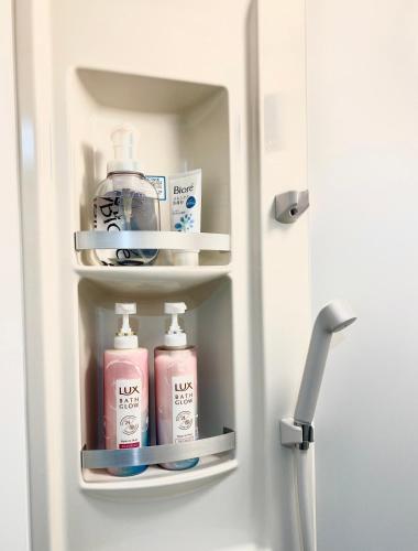 a refrigerator with bottles of soap and other bathroom products at Koenji loft apartment/Shinjuku&Kichijoji/JR in Tokyo