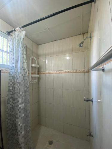 La salle de bains est pourvue d'une douche avec rideau de douche. dans l'établissement Acogedora vivienda anexa en un barrio tranquilo, à David