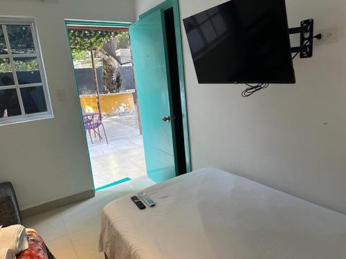 a room with a bed and a flat screen tv at Hotel CastilloMar in Cartagena de Indias