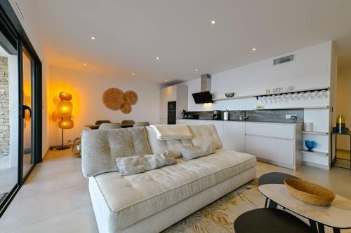 un salon avec un canapé et une cuisine dans l'établissement Le Galatée, T3 luxe, à Porticcio