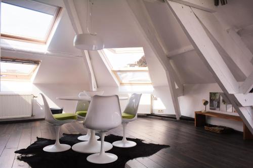 a room with a table and chairs and windows at Entre Deux Pays Apartments in Spa