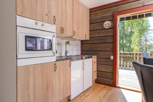 a kitchen with a stove and a microwave at Vimmerby Camping in Vimmerby