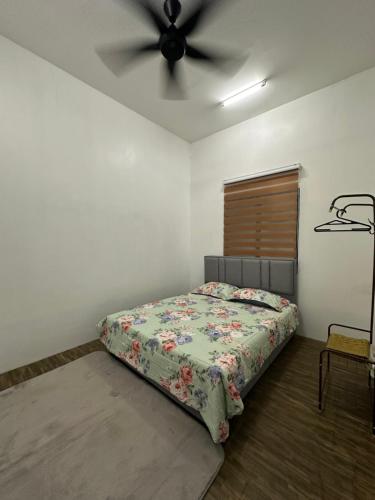 a bedroom with a bed and a ceiling fan at Seriemas Angler Venture Homestay in Sepang