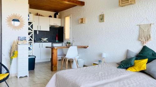 a bedroom with a bed and a small kitchen at Studio Cocody 228 LUMIO in Lumio