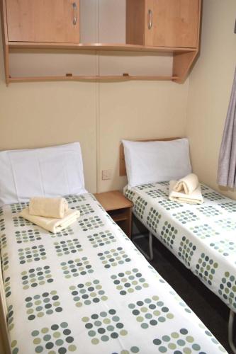 two beds sitting next to each other in a room at Albany Bronze - pet friendly LC19 in Minehead