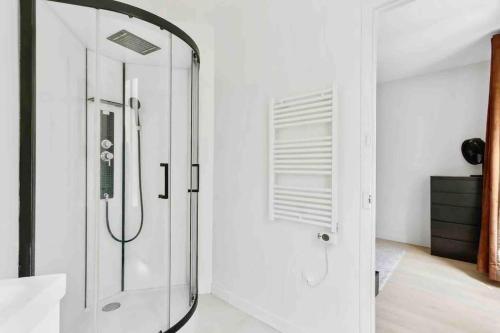 La salle de bains est pourvue d'une douche et d'une porte en verre. dans l'établissement Paris / Charming quiet and spacious apartment, à Boulogne-Billancourt