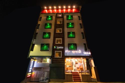 ein hohes Gebäude mit grüner und roter Beleuchtung in der Unterkunft Treebo Trend Kharadi Residency - Near EON IT Park in Pune