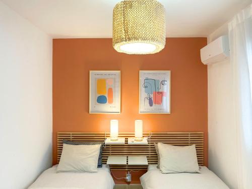 a bedroom with two beds and a chandelier at Moderne, lumineux, balcon, piscine, parking in El Campello