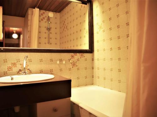 une salle de bain avec un lavabo et une baignoire dans l'établissement Studio cabine au pied des pistes, balcon, parking, animaux admis - FR-1-297-16, à Auris
