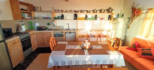 una pequeña cocina con mesa y sofá en Habitación Matrimonial en Totoralillo Glamping, en Totoralillo