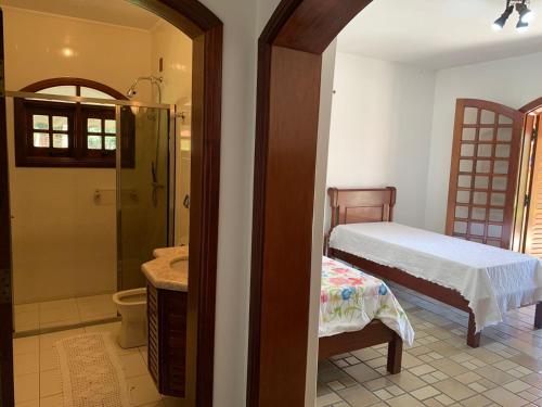 1 dormitorio con 1 cama y baño con lavamanos en Linda Chácara em Piracaia SP en Piracaia