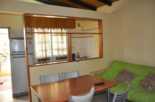 a living room with a table and a green couch at HUGO 3 in Colón