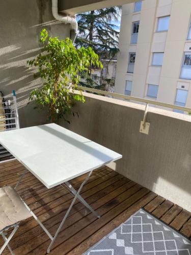 une table blanche sur un balcon avec une plante dans l'établissement Chambre confortable bordeaux, à Bordeaux