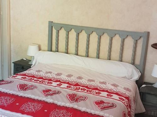 - un lit doté d'un couvre-lit rouge et blanc avec le cœur dans l'établissement Appartement T2 avec Balcon, Centre de Cauterets, Près des Thermes et Remontées Mécaniques - FR-1-234-121, à Cauterets