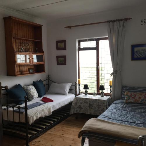 a bedroom with two beds and a window at Prestone Cottage in Cape Town