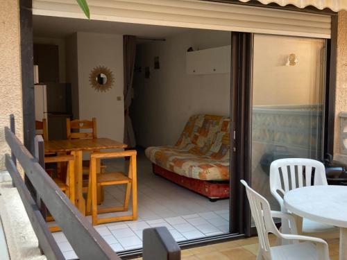 une chambre avec un lit, une table et des chaises dans l'établissement studio cabine mer, à Port-la-Nouvelle