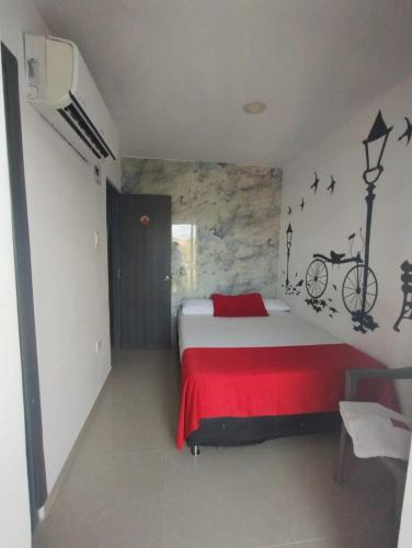 1 dormitorio con 1 cama con una bicicleta en la pared en HOTEL BELLAMAR, en Cartagena de Indias