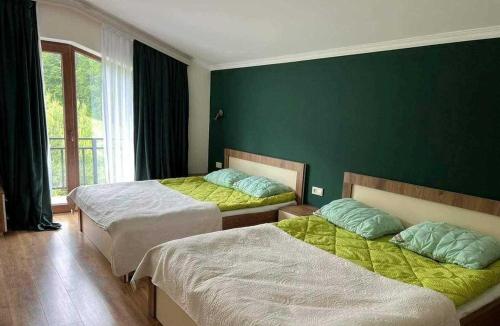 1 dormitorio con 2 camas y pared verde en 2.040 en Bakuriani