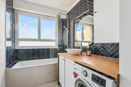 - une buanderie avec un évier et un lave-linge dans l'établissement Symphonie de l'élégance à javel by Weekome, à Paris