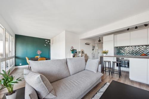 un salon avec un canapé et une cuisine dans l'établissement Symphonie de l'élégance à javel by Weekome, à Paris