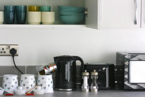 a kitchen counter with a coffee maker and coffee cups at The Birmingham Boutique in Birmingham
