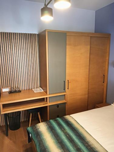 a bedroom with a desk and a bed and a desk and a cabinet at Anais Chalet in Câmpulung Moldovenesc
