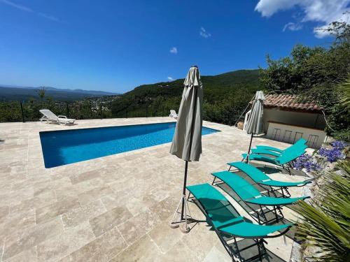 eine Gruppe von Stühlen und Sonnenschirmen neben einem Pool in der Unterkunft Stunning Villa 5 bedroom Heaven on earth in Tourrettes-sur-Loup