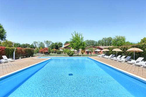 a large swimming pool with chairs and umbrellas at Agriturismo La Fattoria in Panicarola