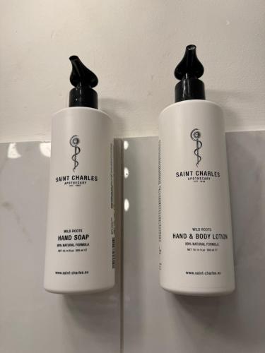 two white bottles of soap sitting on a shelf at Theaterhotel & Suites Wien in Vienna