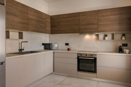 a kitchen with white counters and wooden cabinets at Argostoli Cityscape Apartment in Argostoli
