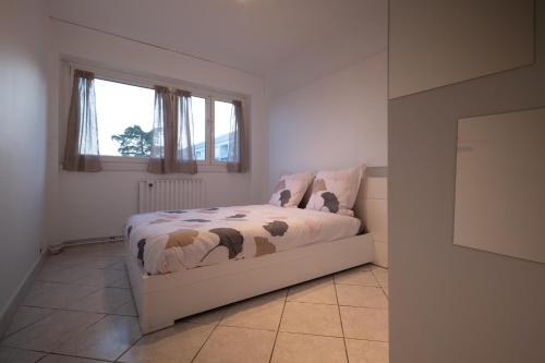 1 dormitorio con 1 cama en una habitación con ventana en APPARTEMENT ARENA/ GROUPAMA STADIUM/ EUREXPO, en Décines-Charpieu