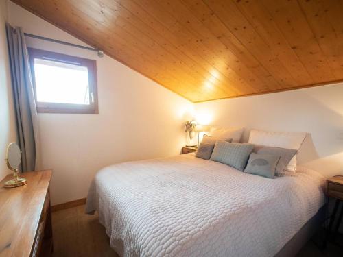 um quarto com uma cama branca e um tecto de madeira em Appartement Valmorel, 4 pièces, 6 personnes - FR-1-291-791 em Valmorel